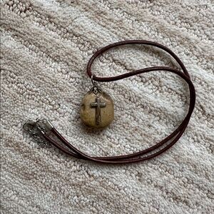 A pendant made of stone pebble from the Sea of Galilee with a Cross